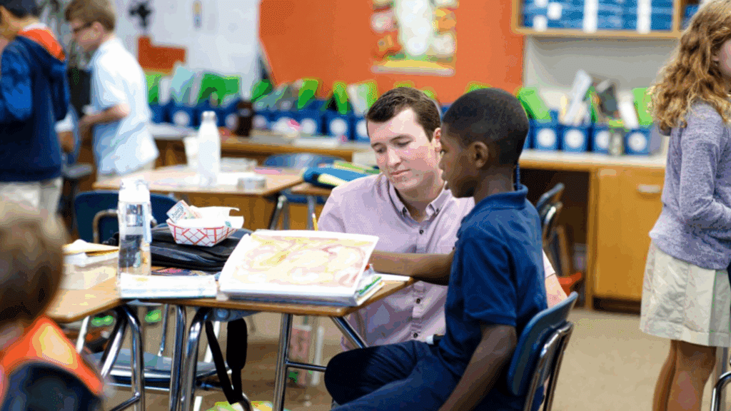 Image of a teacher helping a student in the classroom.