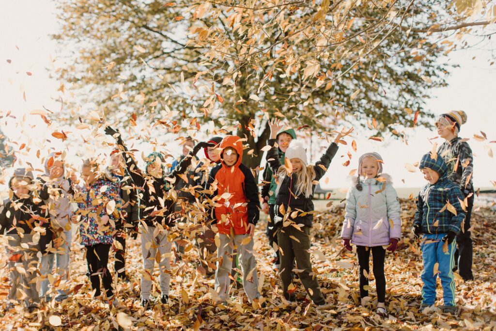 Fall photo of Sully Christian School students playing with leaves