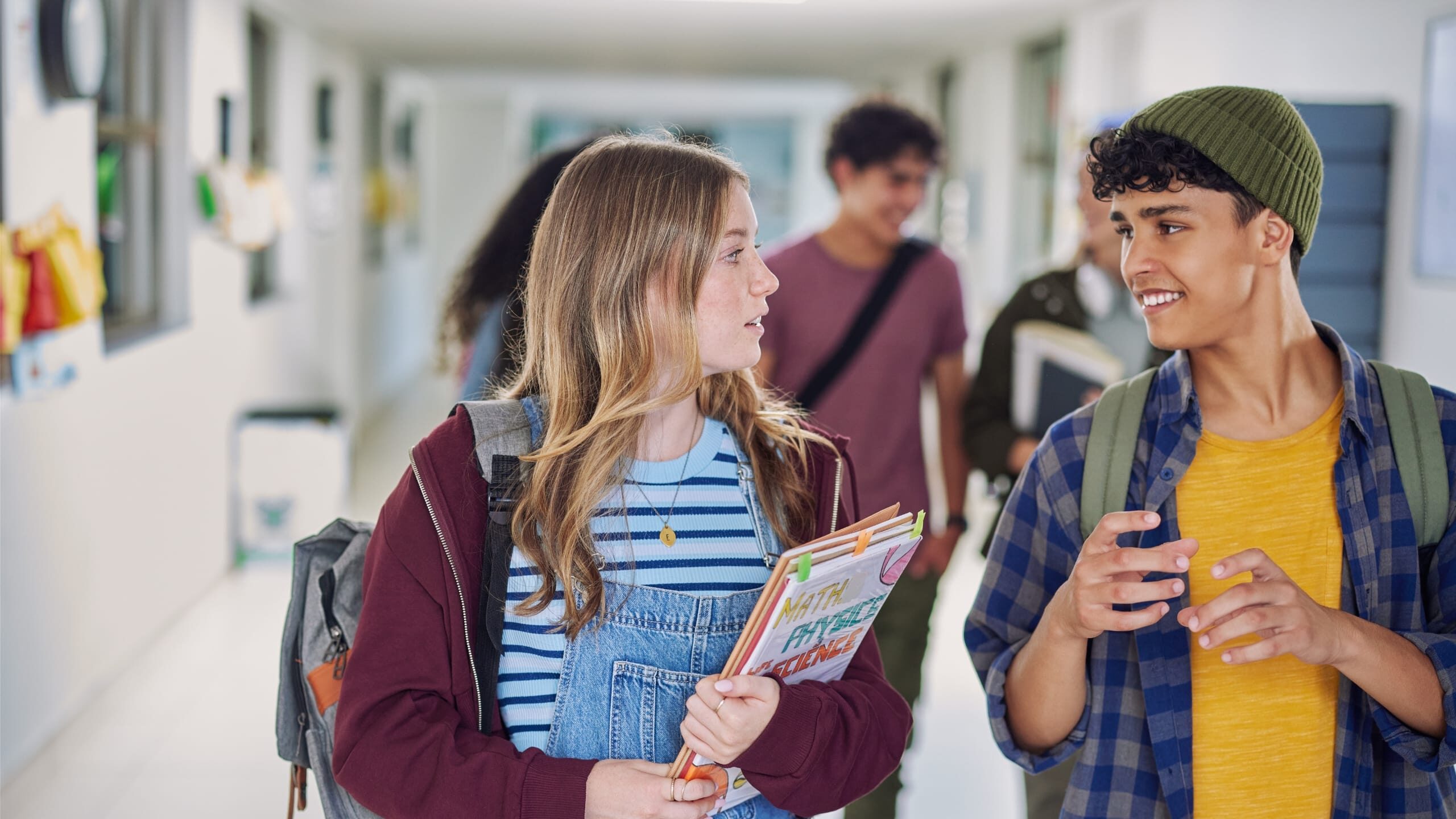 A photo of students walking and talking together in a school hallway.